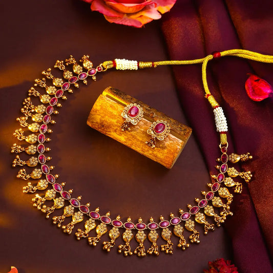 Antique Gold necklace with red stones on a red background