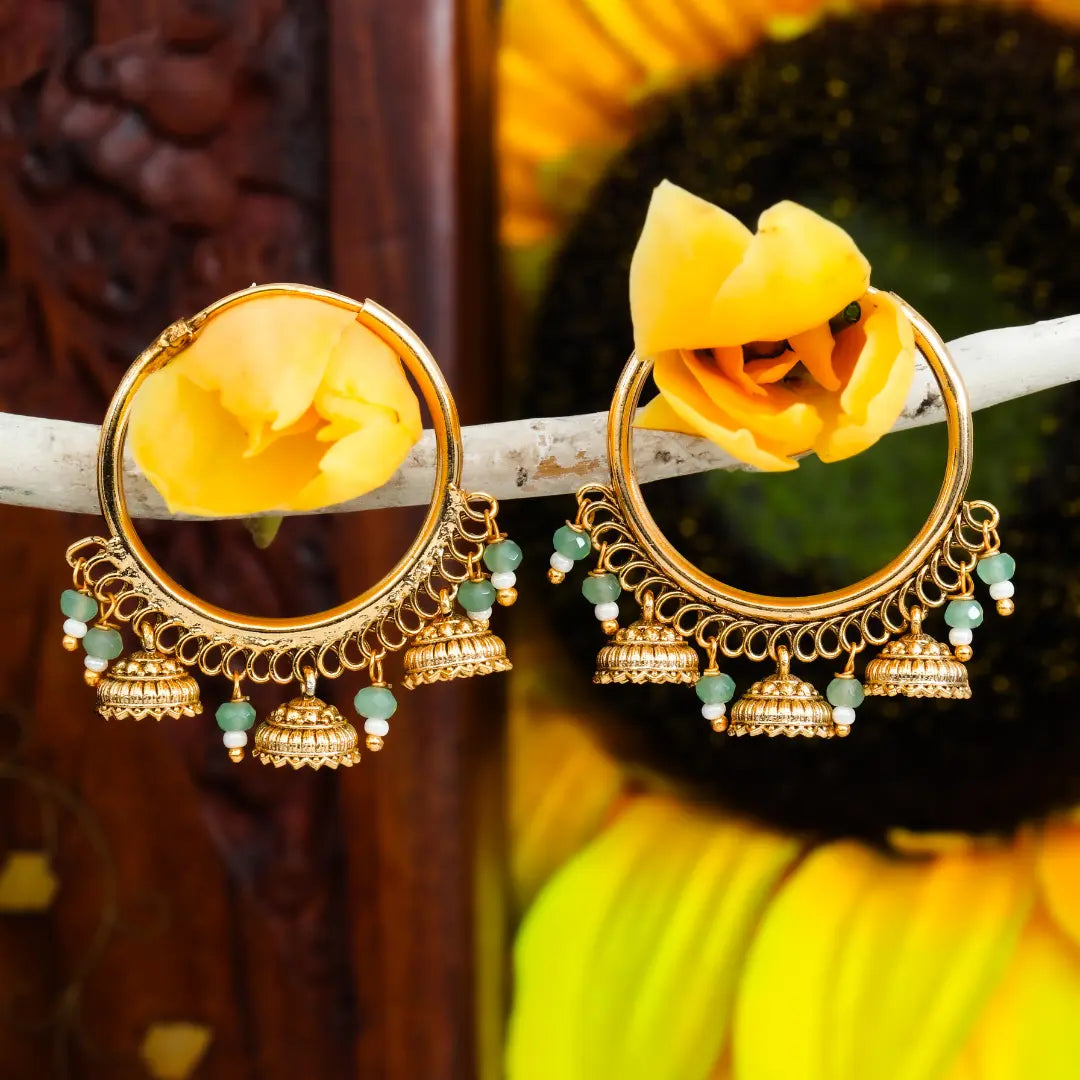 Gold earrings with yellow stones on a sunflower background