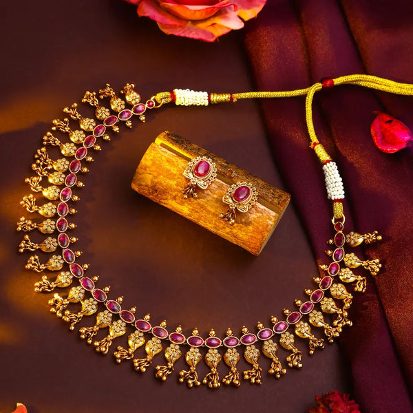 Antique Gold necklace with red stones on a red background