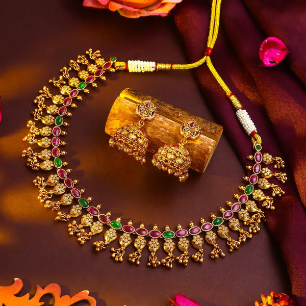Antique Gold necklace with red-green stones on a red background