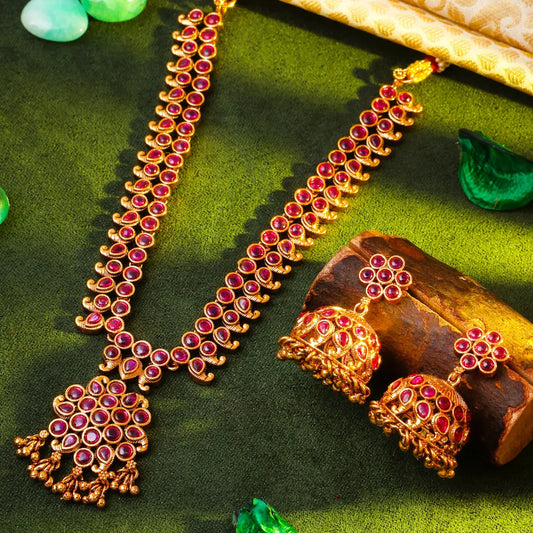 Antique Temple necklace Set with red gemstones on a green fabric background