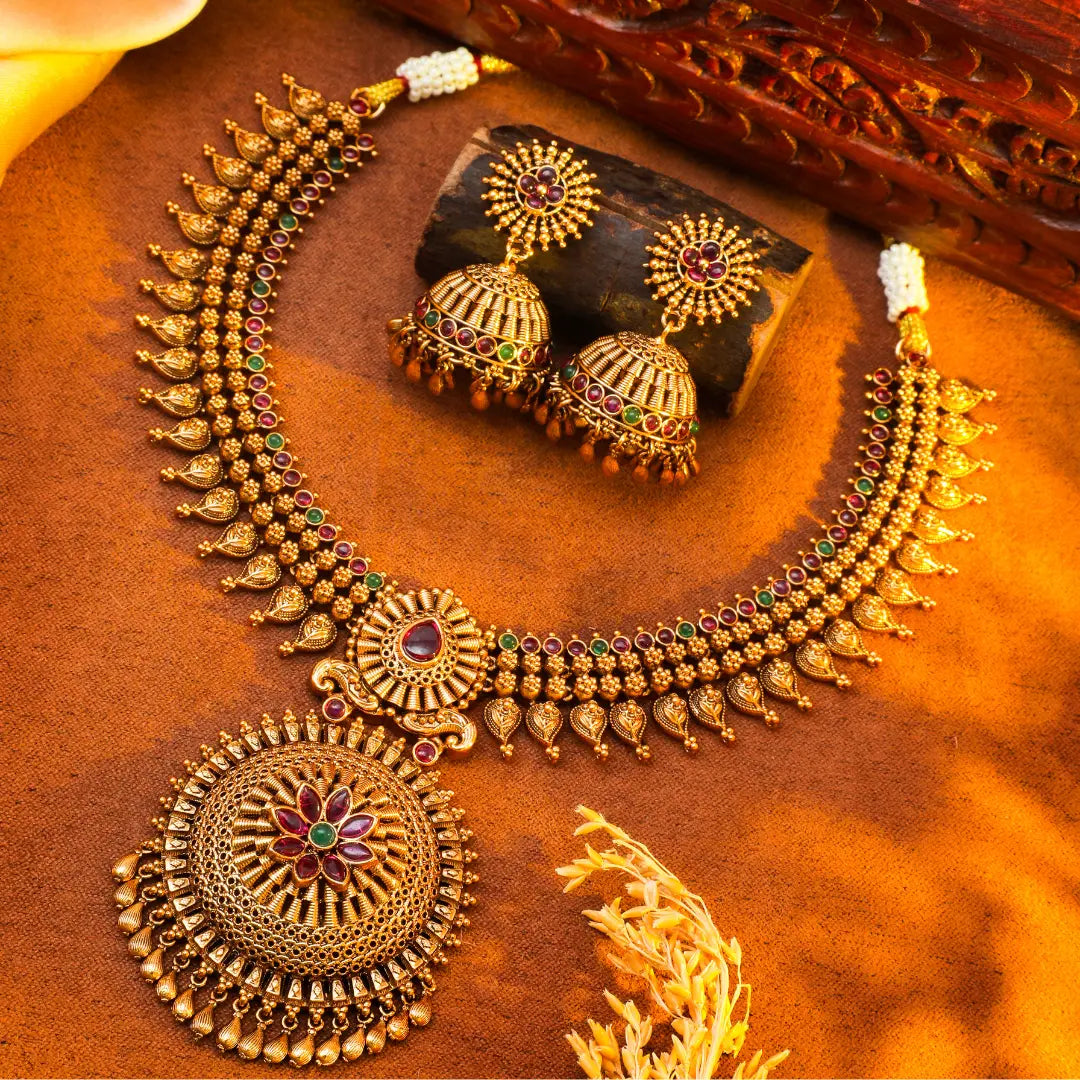 Temple necklace and earrings on a textured brown surface