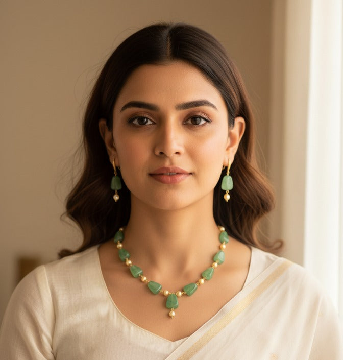 Woman wearing a green necklace and earrings