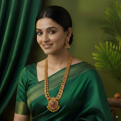 Woman wearing a green saree with gold jewelry against a green background
